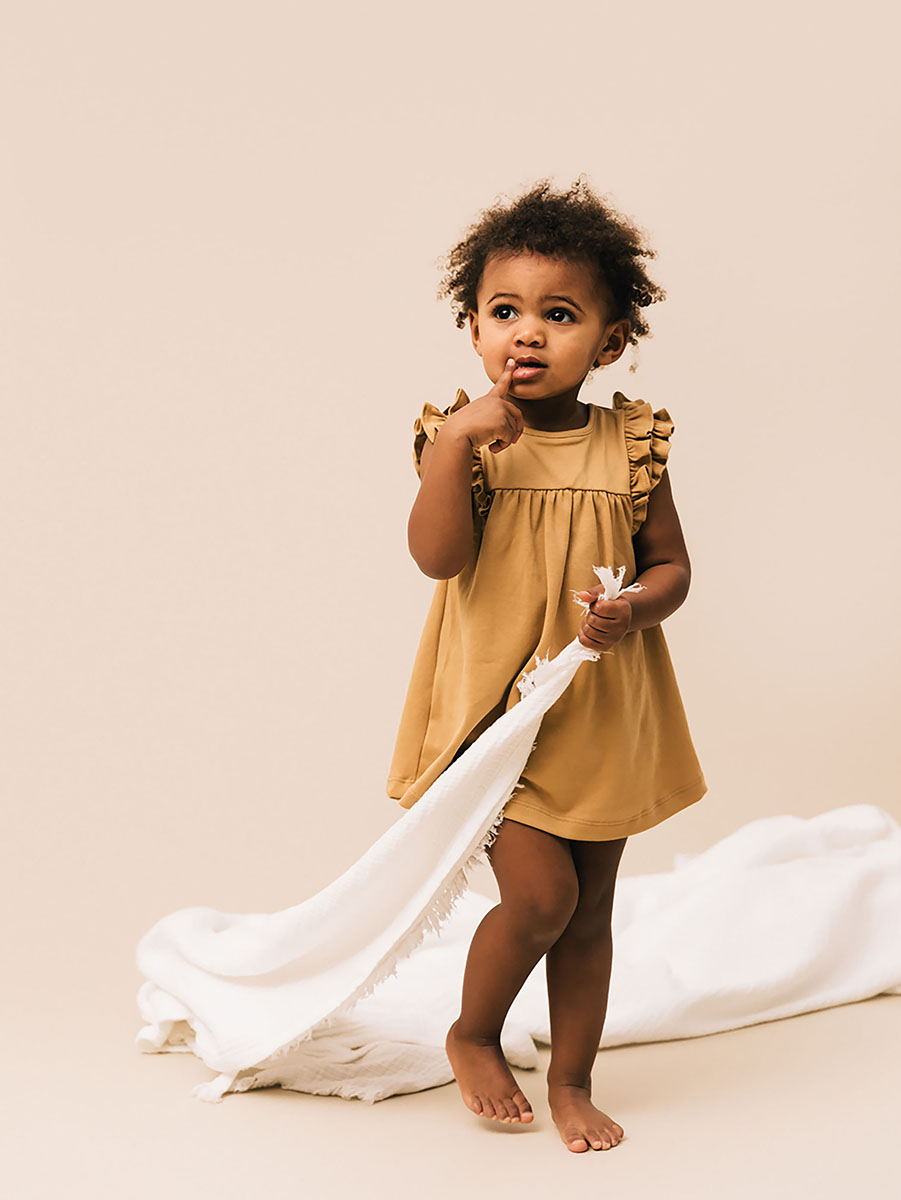 Toddler girl wearing dress in biscotti colour | UAUA Collections