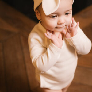 Baby girl wearing outfit and baby hair ribbon in pima cotton - perla - Puno Collection | UAUA Collections